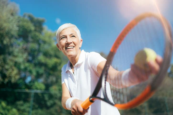Senior Tennis – Pretty Mature Woman Serving Ball in Tennis
