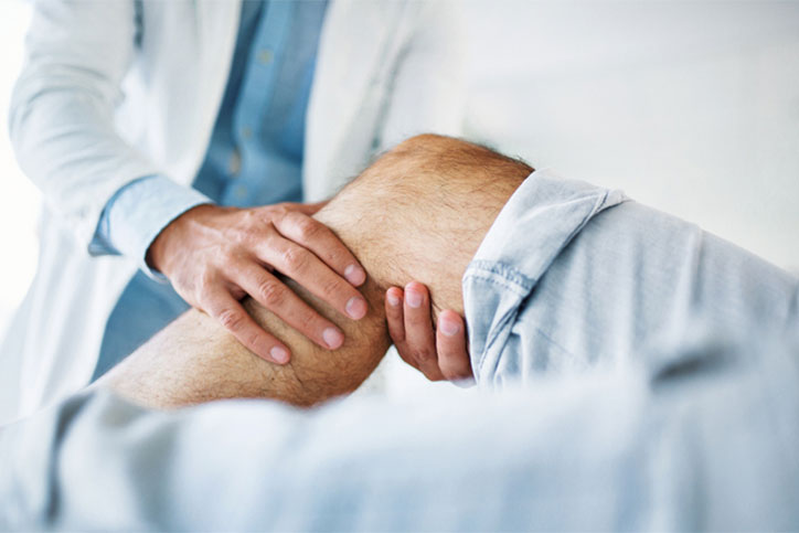 Doctor Holding Knee Pain