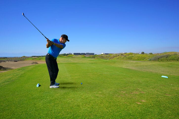 Golfer with Green Grass and Blue Sky